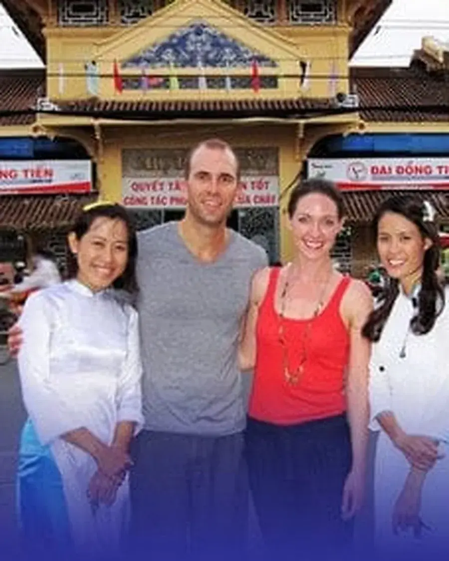 XO Tours guides and guests outside a traditional market gate in Cho Lon